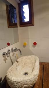 baño con lavabo de piedra y ventana en CAL GERARD - ARCAVELL, en Arcabell