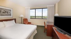 a hotel room with a bed and a television at NCED Conference Center & Hotel in Norman