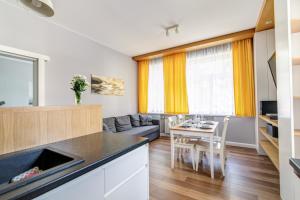 a kitchen and living room with a table and chairs at Krynica Apartamenty Apartament Słoneczny Deptak in Krynica Zdrój