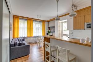 cocina y sala de estar con sofá y mesa en Krynica Apartamenty Apartament Słoneczny Deptak, en Krynica-Zdrój