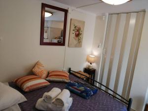 een slaapkamer met een bed met handdoeken en een spiegel bij Rodomelo Cute Studio 1 in Leonidion