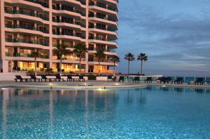 a hotel with a swimming pool in front of a building at ESMERALDA LUXURY #603B in Puerto Peñasco