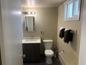 ein Badezimmer mit Toilette, Waschbecken und Spiegel in der Unterkunft Okanagan Royal Park Inn by Elevate Rooms in Vernon + 28 Fotos