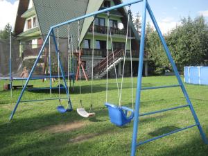 eine Schaukel im Hof eines Hauses in der Unterkunft Hacjenda - Apartamenty i Pokoje Gościnne in Czarna Góra