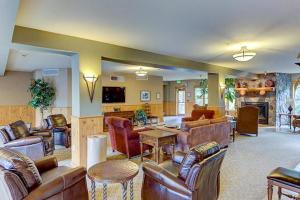 a living room with leather furniture and a fireplace at Tenderfoot Lodge in Keystone