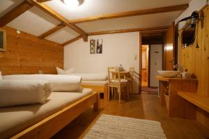 a bedroom with two beds and a kitchen with a table at Apartment Jaegerhaus in Andelsbuch