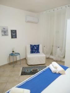 a white room with a bed and a couch at La Casa di Bianca in Caltagirone +30 photos