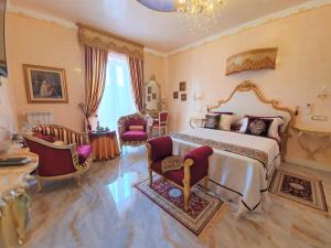 Schlafzimmer mit einem Kingsize-Bett und Stühlen in der Unterkunft FD Luxury rooms in Verona
