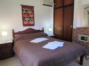 a bedroom with a bed with two towels on it at Cabañas El Maiten in Merlo