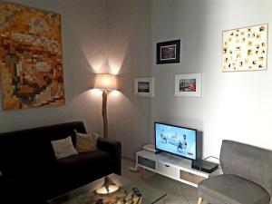 a living room with a couch and a flat screen tv at Le Barrème in Arles