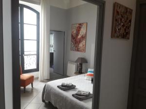 a bedroom with a bed and a window and a mirror at Le Barrème in Arles