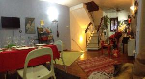 uma sala de estar com uma mesa com uma toalha de mesa vermelha em La Torretta em Orte