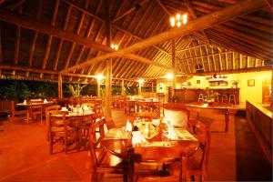 a restaurant with tables and chairs in it at Luna Lodge in Carate