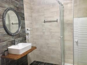 a bathroom with a sink and a glass shower at Almira - rooms to let in Nea Roda