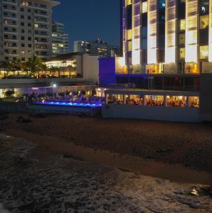 a building on the beach at night at Condado Ocean Club - Adults Only in San Juan +30 photos