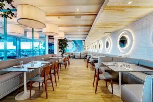 a dining room with tables and chairs and windows at Condado Ocean Club - Adults Only in San Juan