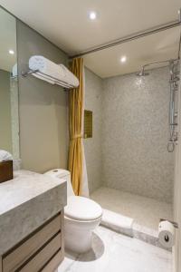 
a bathroom with a shower, toilet and sink at Casa Malí by Dominion Boutique Hotel in Mexico City
