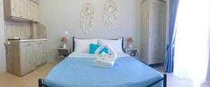 a bedroom with a blue bed with a basket on it at Almira - rooms to let in Nea Roda