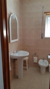 a bathroom with a sink and a mirror and a toilet at Alojamentos S.José in Atouguia da Baleia +33 photos