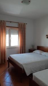 a bedroom with two beds and a window at Alojamentos S.José in Atouguia da Baleia