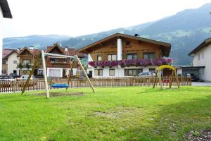 un parco con altalene davanti a una casa di Arenablick a Zell am Ziller