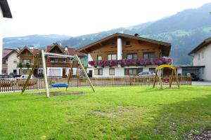 a park with swings in front of a house at Arenablick in Zell am Ziller