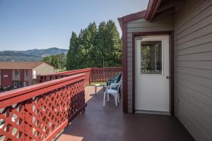 a balcony with a white door and chairs on it at Riverview Lodge in Hood River