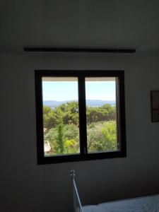 a window in a bedroom with a view of trees at Apartments Kupine in Bol