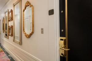 a hallway with gold framed mirrors on a wall at Staypineapple, An Elegant Hotel, Union Square in San Francisco