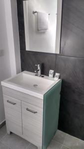 bagno con lavandino bianco e specchio di HOTEL EL EDEN IXTAPALUCA a Ixtapaluca