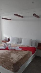 a bedroom with a large bed with towels on it at HOTEL EL EDEN IXTAPALUCA in Ixtapaluca
