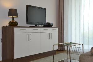 a living room with a tv on top of a dresser at Oberberghof in Appiano sulla Strada del Vino
