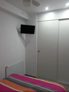 ein Schlafzimmer mit einem Bett und einem Fernseher an der Wand in der Unterkunft Acogedor apartamento con vistas al mar. in Bellreguart