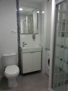 ein Badezimmer mit Toilette, Waschbecken und Spiegel in der Unterkunft Acogedor apartamento con vistas al mar. in Bellreguart