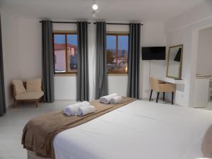 - une chambre avec un grand lit et 2 serviettes dans l'établissement KINGS SQUARE Holiday Apartments, à Pólis Chrysochoús