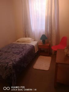 ランカグアにあるRelajado y centralの小さなベッドルーム(ベッド1台、赤い椅子付)