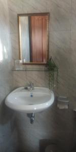 a white sink in a bathroom with a mirror at Serongga guest house in Lebih