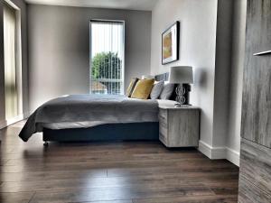 a bedroom with a bed and a window at AMAZING & SPACIOUS 2 Bed 2 Bath LUXURY Apartment with BALCONY FREE WIFI Sleeps 6 in Bushey