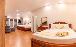 a bedroom with a large bed and a mirror at Thanh Do Hotel in Da Lat