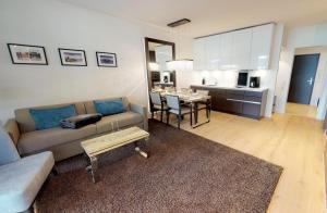 een woonkamer met een bank en een tafel bij White Pearl Apartment 0.12 in Timmendorfer Strand