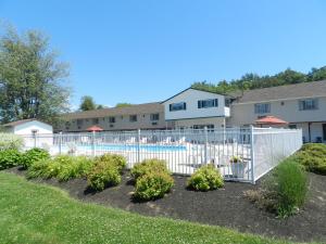 a white fence in front of a yard with plants at C-Way Resort in Clayton