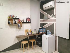 a kitchen with a desk and two stools and a refrigerator at In.T in Tainan