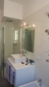 uma casa de banho branca com um lavatório e um espelho em Al Pergolesi B&B em Iesi