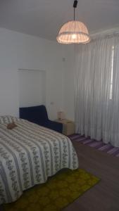1 dormitorio con cama y lámpara de araña en Al Pergolesi B&B, en Iesi