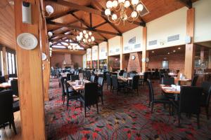 a dining room with tables and chairs and a chandelier at Hogans Motel in Wallan