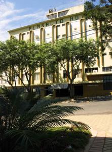 a large white building with trees in front of it at Planalto Hotel in Canoinhas
