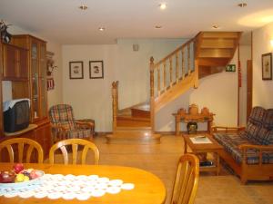 ein Wohnzimmer mit einem Tisch und einer Treppe in der Unterkunft Casa Duplex La Buhardilla in Torla-Ordesa