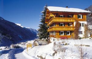 un edificio en una colina cubierta de nieve con una carretera en Appart Fernblick, en Gaschurn