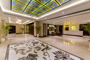 a lobby with a ceiling with a stained glass ceiling at Lemon Tree Hotel Jammu in Jammu