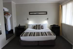 Un dormitorio con una cama grande y una ventana en Quality Inn Acapulco Taupo, en Taupo